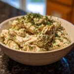 A bowl of Delicious Healthy Ranch Chicken Salad topped with fresh dill.