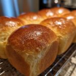 Gouden, glanzende First Air Fryer Brioche broodjes op een rooster.