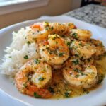 Close-up van Hawaïaanse knoflookgarnalen geserveerd met witte rijst en bestrooid met peterselie.