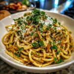 A close-up of Irresistible Caramelized Onion Pasta, topped with fresh parsley and grated cheese.