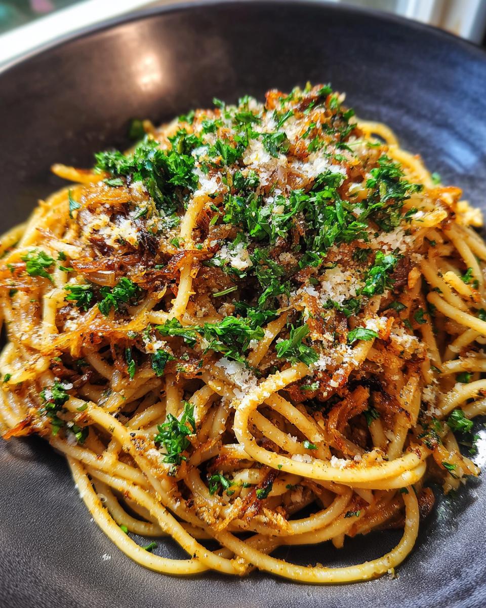 Close-up of Irresistible Caramelized Onion Pasta topped with fresh parsley and grated cheese.