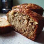 Close-up of a slice of Irresistible Hazelnut Banana Bread, showing texture and nuts.