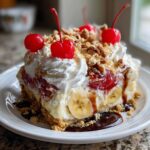 A slice of Irresistible No Bake Banana Split Dessert with whipped cream, cherries, nuts, and banana slices.