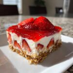 A delicious slice of Irresistible Strawberry Pretzel Jello Salad, featuring a pretzel crust, creamy filling, fresh strawberries, and strawberry jello topping.
