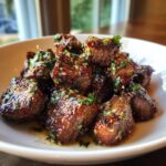 Close-up of Irresistible Juicy Garlic Butter Steak Bites, glistening with butter and herbs.
