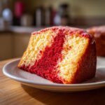 Een close-up van een plak Red Velvet Pound Cake met marmerpatroon op een wit bord.