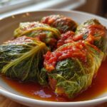 Close-up van heerlijke Stuffed Cabbage Rolls in een romige tomatensaus, geserveerd in een witte schaal.