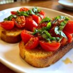 Twee sneetjes geroosterd brood belegd met verse tomaten, basilicum en kruiden: Tomato Basil Bruschetta.