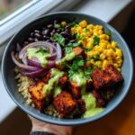 A vibrant bowl of Zesty Cilantro Lime Tofu Bowls with quinoa, black beans, corn, red onion, and cilantro-lime dressing.
