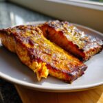 Two perfectly cooked fillets of Air Fryer Mustard Salmon with a golden, caramelized mustard crust, served on a light gray plate.