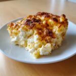 A close-up of a square serving of Baked Macaroni With Feta Cheese, featuring a golden-brown, bubbly top crust.
