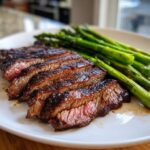 Close-up of sliced steak with a side of roasted asparagus, a perfect cheap Fathers Day dinner idea.
