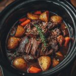 Close-up of a crock pot filled with tender pot roast, potatoes, and carrots, perfect for a Father's Day feast.