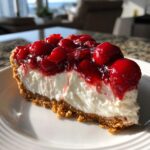 A slice of Irresistible No Bake Cherry Cheesecake Recipe Delight on a white plate, showing the creamy filling and cherry topping.