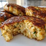 Close-up of Irresistible Salmon Cakes With Canned Salmon Recipe, showing a golden-brown crust and flaky interior with visible salmon pieces and herbs.