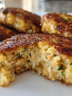 Close-up of Irresistible Salmon Cakes With Canned Salmon Recipe, showing a golden-brown crust and flaky interior with visible salmon pieces and herbs.