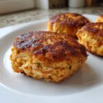 Close-up of golden-brown, pan-fried Irresistible Salmon Cakes With Canned Salmon Recipe on a white plate.