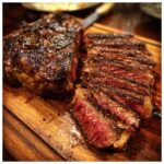 A perfectly grilled steak, sliced to reveal a juicy medium-rare interior, ready to savor for Memorial Day.