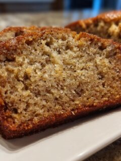 Close-up of two moist slices of homemade Banana Bread showing a rich, brown, speckled crumb texture.