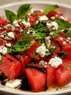 Close-up of a refreshing watermelon feta salad with fresh mint and balsamic glaze.