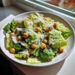 Close-up van een kom La Scala Chopped Salad met Romeinse sla, Parmezaan en krokante kikkererwten.