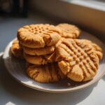 Een stapel goudbruine Cake Mix Peanut Butter Cookies met het klassieke vorkpatroon, liggend op een licht bord.