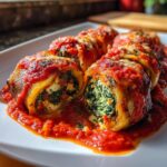 Close-up van Eggplant Rollatini gevuld met spinazie en ricotta, overgoten met tomatensaus en gesmolten kaas.