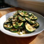 Plat met gegrilde courgette plakjes, feta en verse munt, perfect voor een Gegrilde Zucchini Salade.