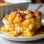 Close-up van een warm stuk Ananas Cobbler met sappige stukjes ananas en een gekarameliseerde topping.