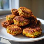 Close-up van een stapel goudbruine, krokante gebakken falafel op een wit bord, perfect voor het recept.
