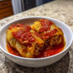 Twee heerlijke Macedonische Koolrolletjes geserveerd in een witte kom met rijke tomatensaus.