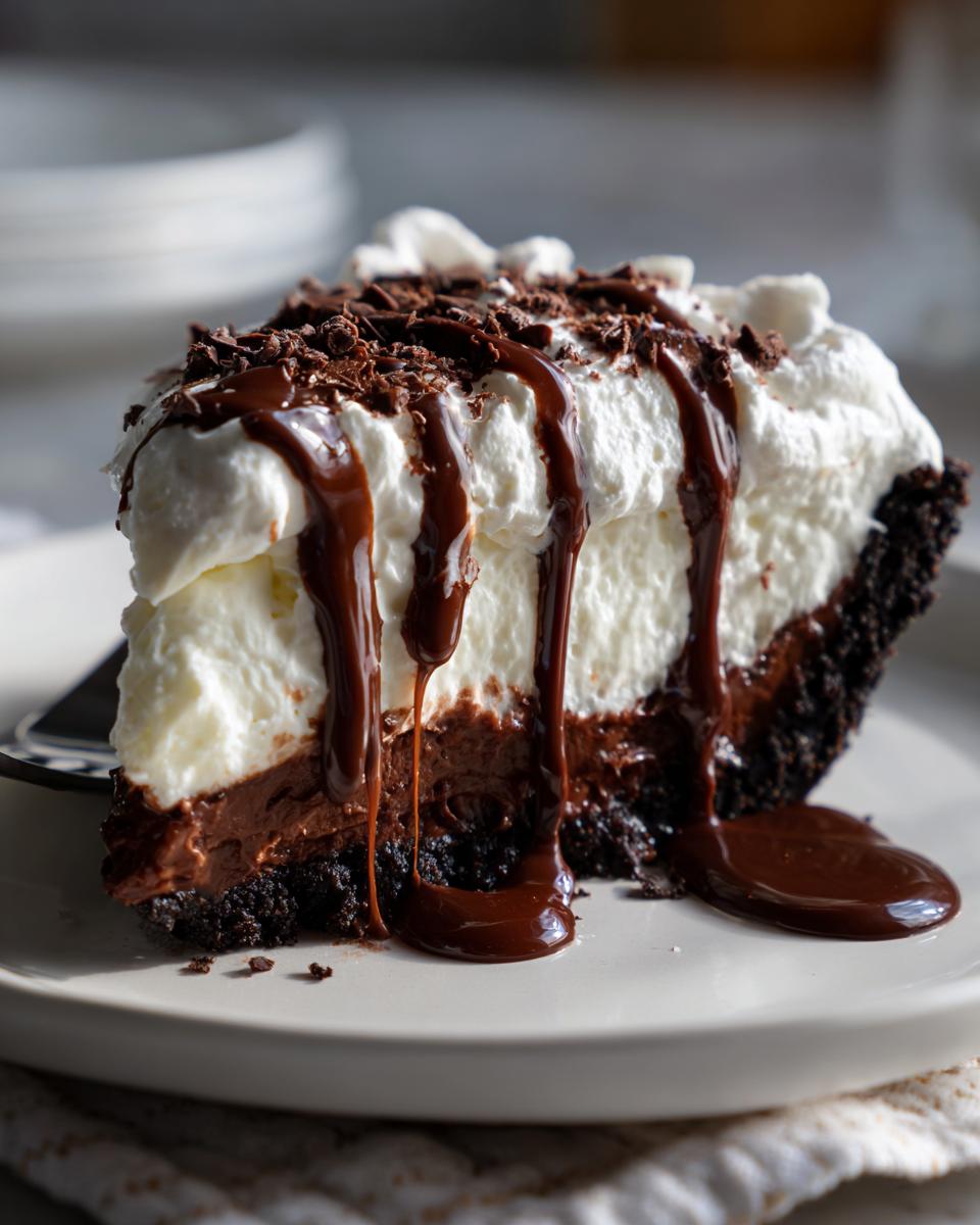 Een groot stuk Mississippi Mud Pie met een donkere bodem, chocoladevulling, slagroom en druipende chocoladesaus.