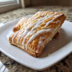 Goudbruine Phyllo Framboos Pop Tarts met een dikke witte vanille glazuur erop.