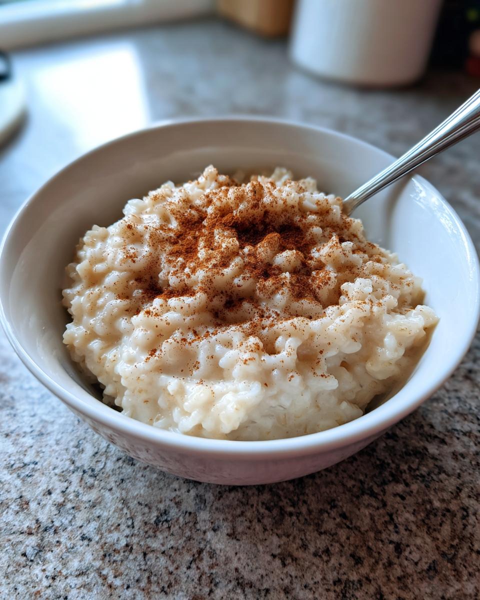 Close-up van een kommetje romige rijstepap, rijkelijk bestrooid met kaneelpoeder.