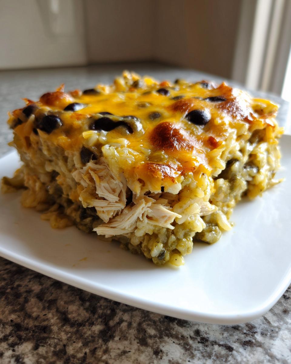 Een portie Salsa Verde Chicken Rice Casserole met gesmolten kaas en zwarte bonen bovenop.
