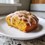 Close-up van een heerlijke Starbucks Pumpkin Scone met een dikke laag wit glazuur erop.