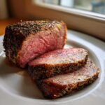 Close-up of a juicy, medium-rare Classic Roast Beef, sliced to show the pink center and herb crust.