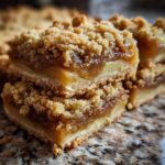Two stacked, thick Apple Pie Bars showing a buttery crust, gooey apple filling, and a crumbly streusel topping.